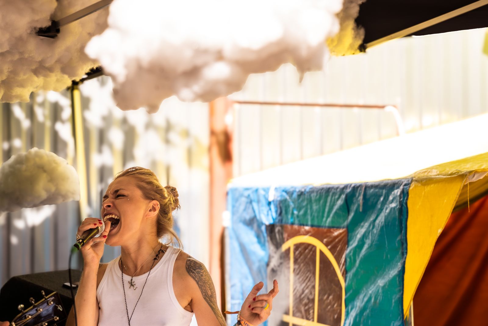 Arnika Aluri singing into a microphone on an outdoor stage